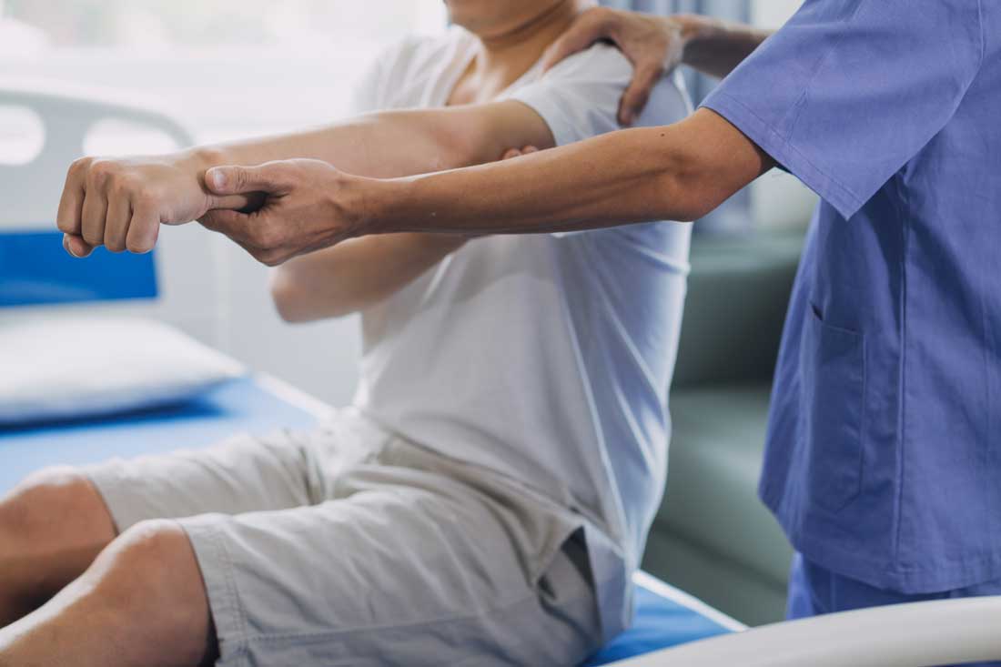 AI image of a man having his arm gently stretched by a therapist