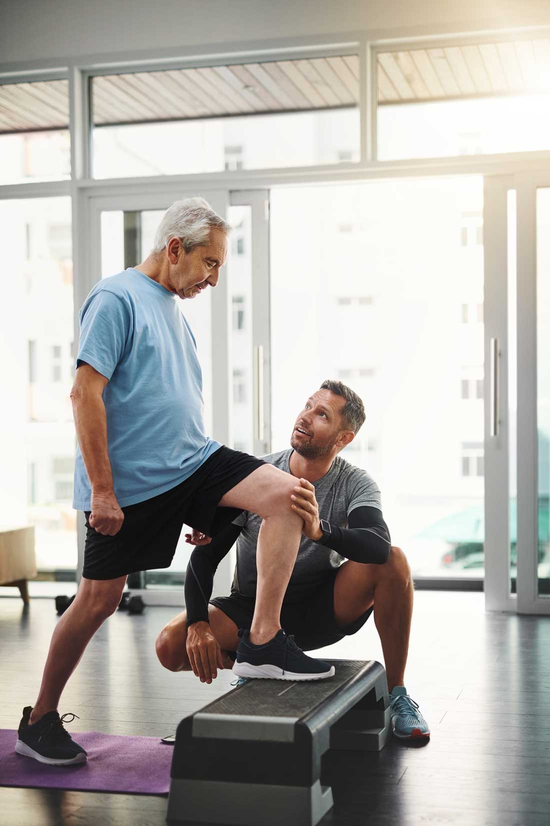 AI image of an elderly man doing a lunge while a young main helps keep his knee steady